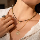 Rückseite der Münzkette "Athena & Pegasus" mit dem geflügelten Pferd Pegasus, Münzanhänger aus einer antiken Münze aus 18 Karat Gold Vermeil. Kombiniert mit Kette Leona aus Obsidian