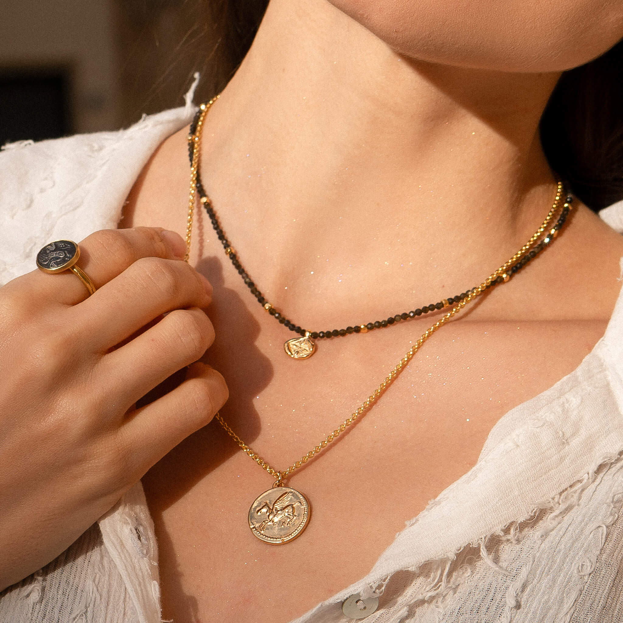 Rückseite der Münzkette "Athena & Pegasus" mit dem geflügelten Pferd Pegasus, Münzanhänger aus einer antiken Münze aus 18 Karat Gold Vermeil. Kombiniert mit Kette Leona aus Obsidian